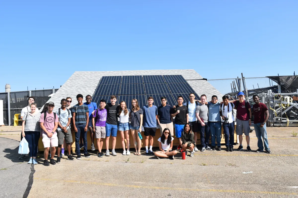 First-year Preorientation Program students with a solar panel.