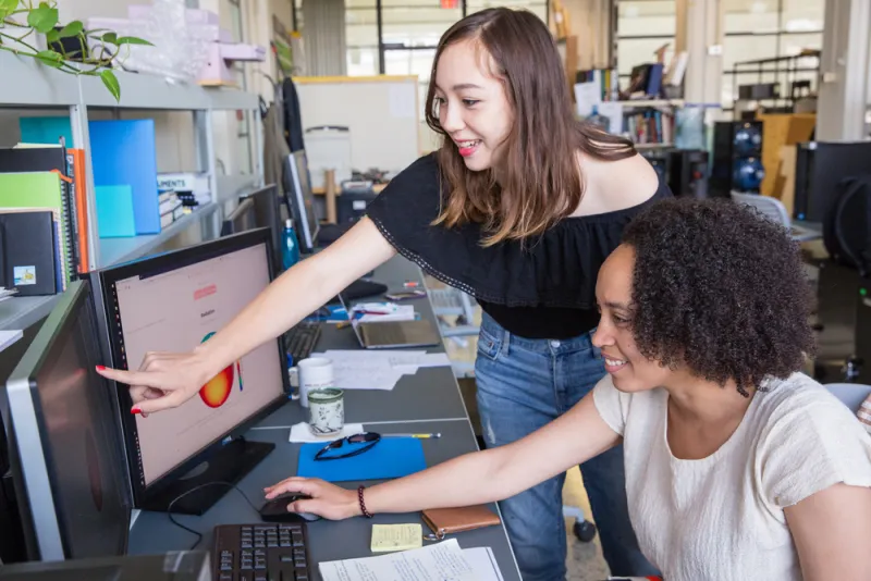 MIT students work together at a computer.