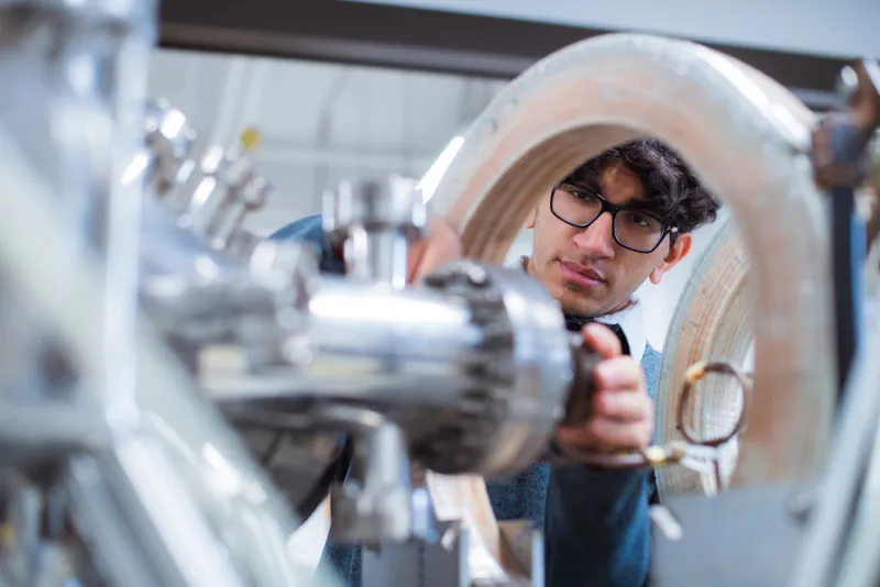 Akarsh Aurora, a student in the FUSar program, works on a machine.