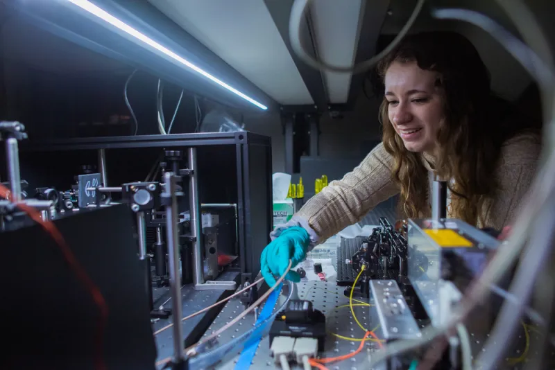 MIT undergraduate student Lauryn Kortman works on a laser as part of her FUSar project.