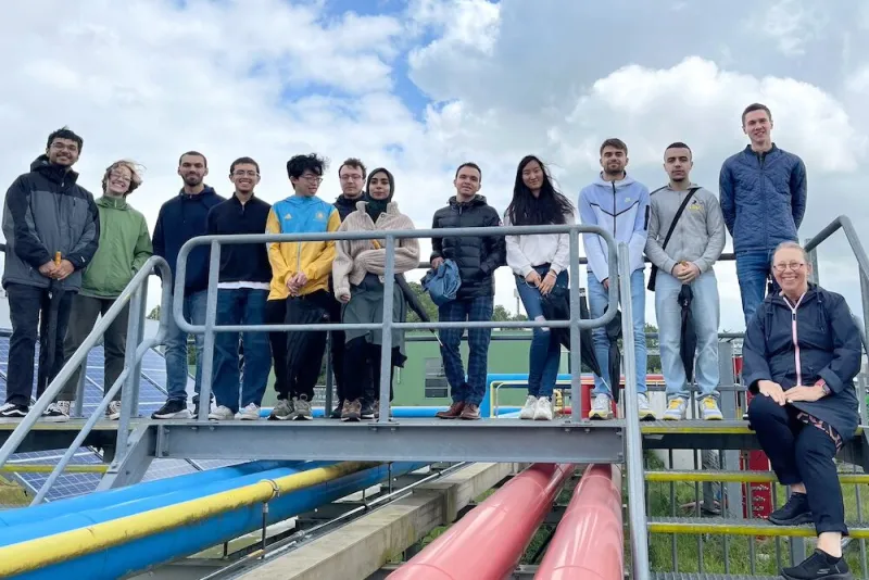 A group of students on a MITEI-sponsored field trip to the Netherlands stand together on an outdoor metal platform.