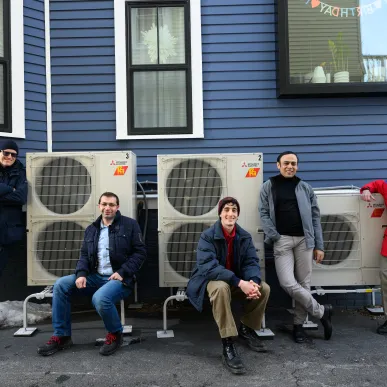 MIT researchers pose with home air conditioning system.